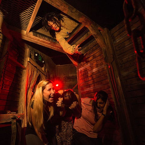 Guests duck out of a scareactor's reach in a hando