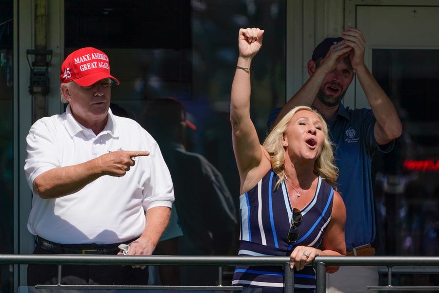 Former President Donald Trump, left, acknowledges the crowd with U.S. Rep. Marjorie Taylor Greene while they look over the 16th tee during the second round of the Bedminster Invitational LIV Golf tournament in Bedminster, NJ., Saturday, July 30, 2022. (AP Photo/Seth Wenig) ORG XMIT: NJSW118