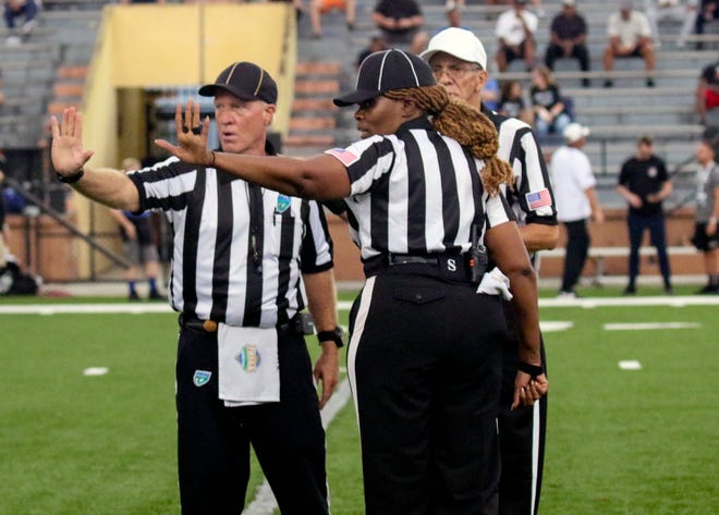 From left, back judge Rob Myers, line judge Carol Lawson and referree Wendall Powell discuss a call during the first half of the kickoff classic between Lakeland and Seffner Armwood on Friday at Bryant Stadium.