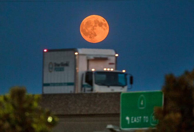 (9/5/17) A full Harvest Moon, turned orange by smokey skies, rises in the east beyond the Crosstown Freeway at Stanislaus Street in downtown Stockton. Detail can be seen in the moon and the foreground due to an equally balance exposure.
