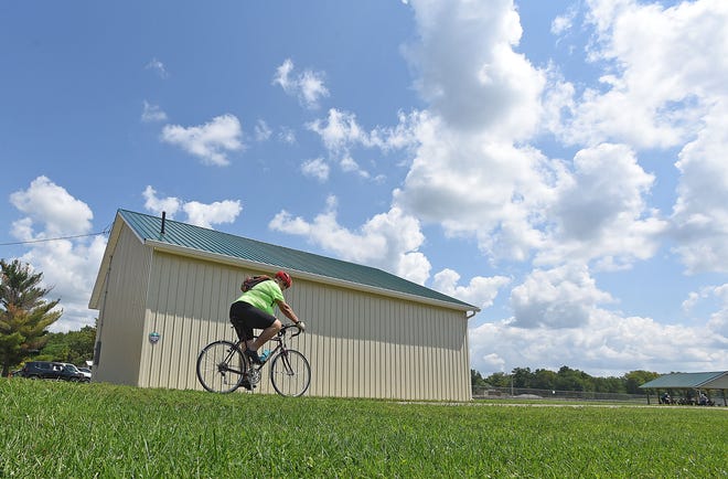 Keith Elliott, of Johnsville, rides passed the new Richland County B&O Bike Trail maintenance building Tuesday afternoon.