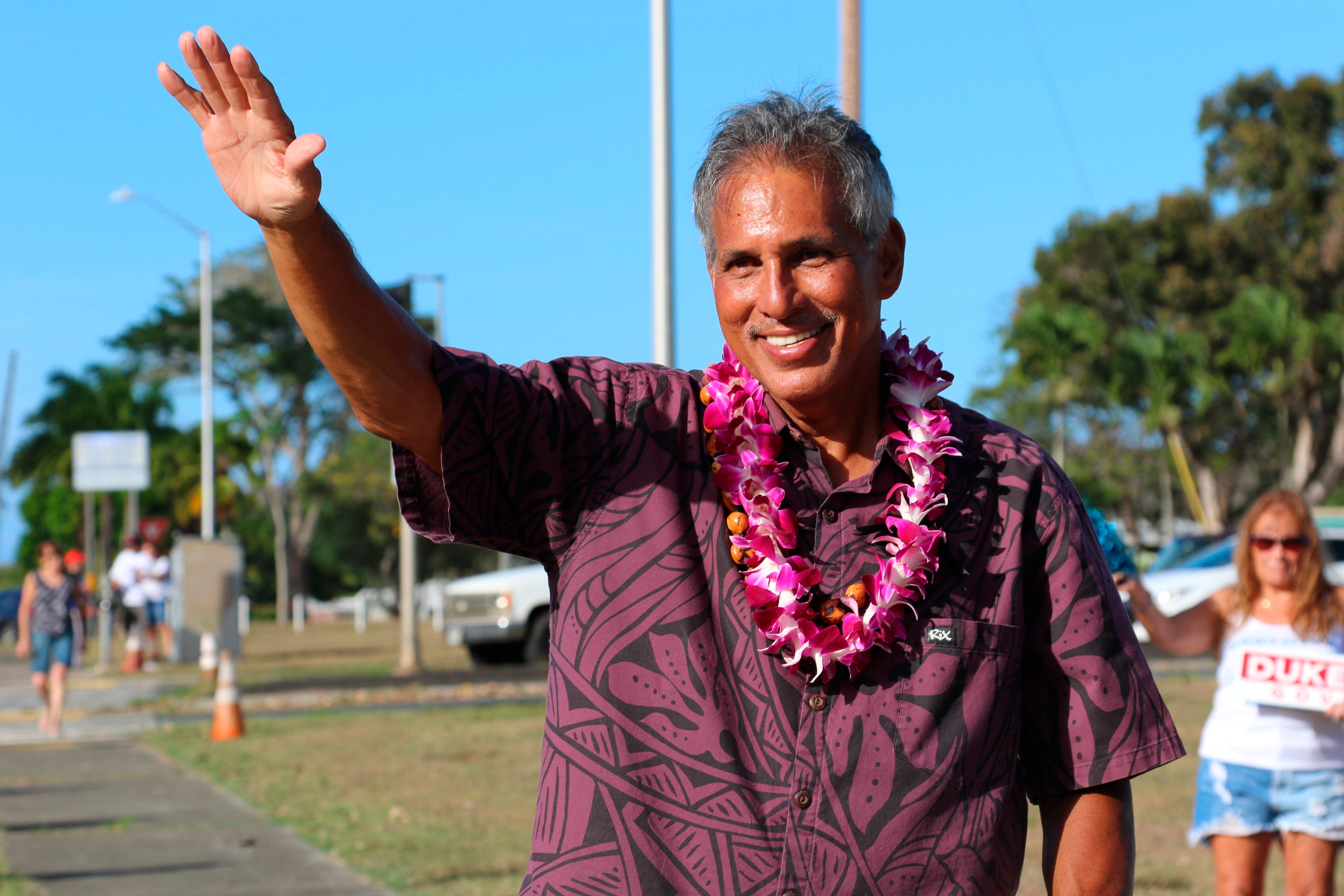 Former Hawaii Lieutenant Governor James R. "duke" Iona waves to passing cars during her election campaign in Kailua, Hawaii on August 9, 2022. Iona is a Republican gubernatorial candidate who has criticized Nomi's campaign contributions to his Democratic rivals.