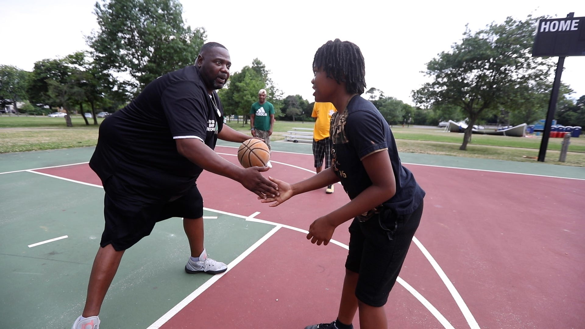  John A. Smith, after a joint MAD DADS and Peacemakers of Western New York meeting at MLK Park in Buffalo, NY. on July 8, 2022 teaches Larry Cooper a dribbling drill.  While keeping your eye on the person in front of you, he had the youth dribble from hand to hand and while switching hands slap his hand.