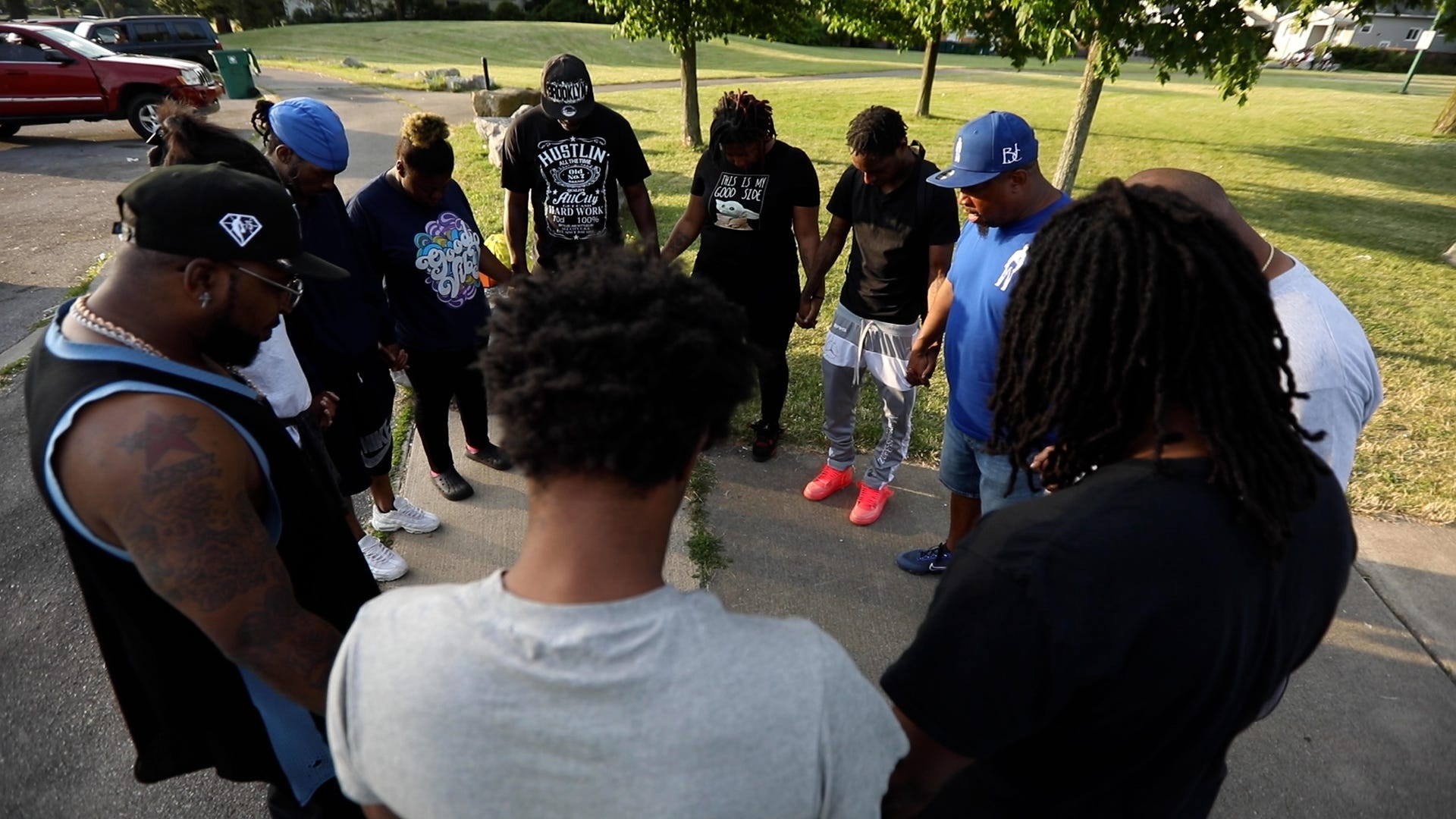 Pastor Kenneth Simmons of Cold Spring Bible Chapel in Buffalo, N.Y., leads a group of young adults in prayer at Schiller Park on June 29, 2022. Simmons had taken a group of young children fishing and after the event was over he saw this group of young adults and asked them if they wanted a prayer; they said yes. Joining them were adults volunteers with the fishing program.