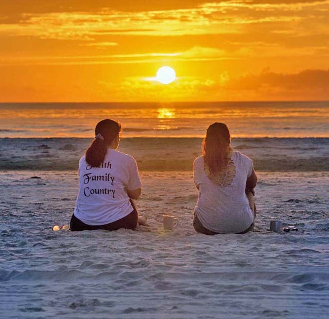 Sarina Gilblom and Caroline Hall watch the sun rise at St. Augustine Beach.