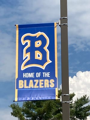 A banner advertising the Clear Spring High School mascot, the Blazers, hands on a light post at the high school near Clear Spring.