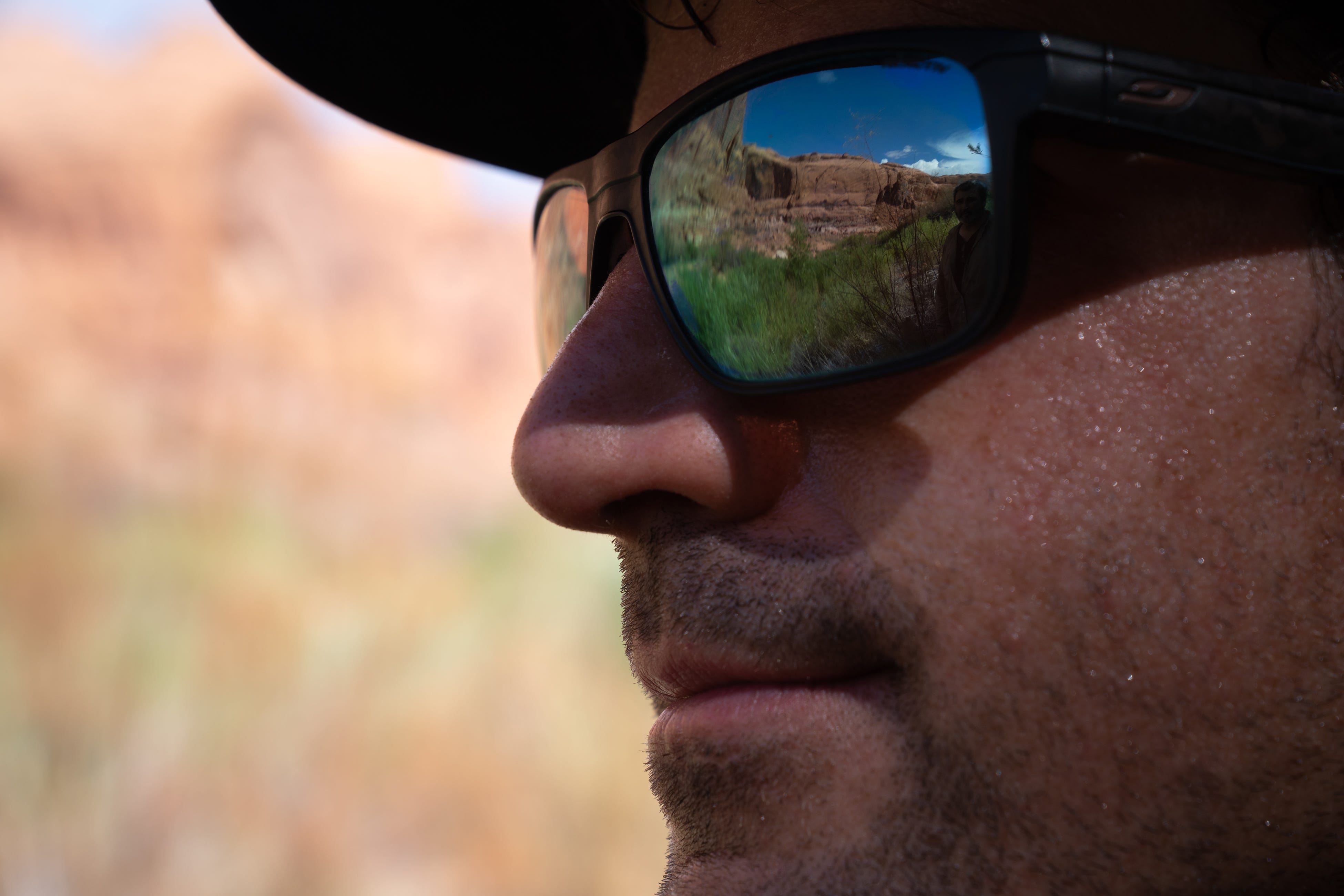 A close up shot of Eric Balken with a canyon at Lake Powell reflected in his sunglasses.
