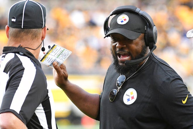 Pittsburgh Steelers head coach Mike Tomlin, right, talks to an official during the first half of a preseason NFL football game against the Seattle Seahawks, Saturday, Aug. 13, 2022, in Pittsburgh. (AP Photo/Fred Vuich)