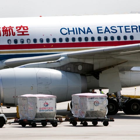 FILE - A carter drives past a China Eastern airlin