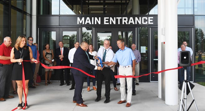 Ames Schools Superintendent Julious Lawson (from left), director of facility Gerry Peters, and former superintendent Tim Taylor cut the ribbon for an open house at the new Ames High School on Saturday. The building welcomed its first students Wednesday.