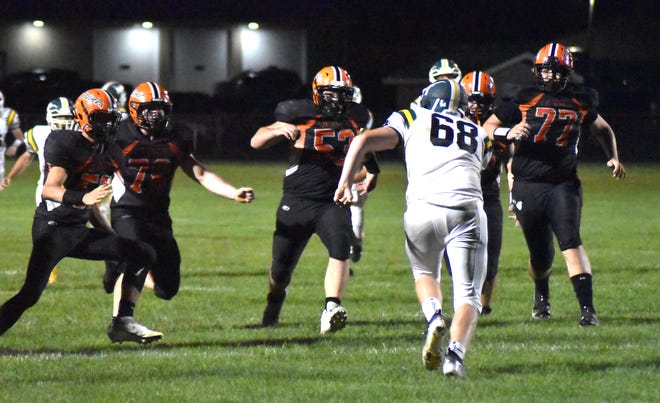 The Quincy defense closes in on a scrambling Sand Creek punter in the closing moments of Friday's game.