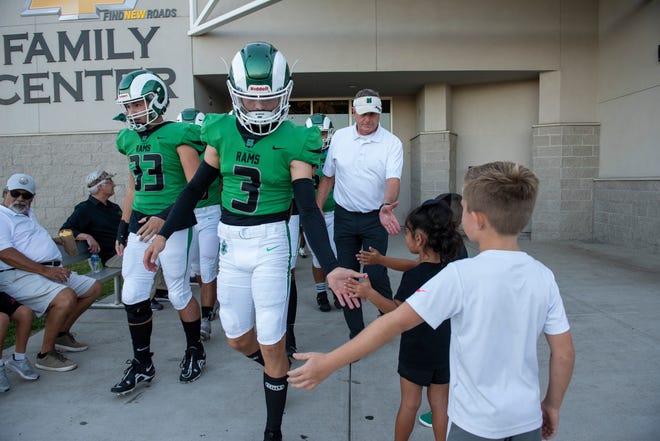 St. Mary's High's Brooks Wheatley low fives McKenna Wright, 3, as the team leaves the locker room before the game against West High on Aug. 26. St. Mary's led 44-0 at the half.