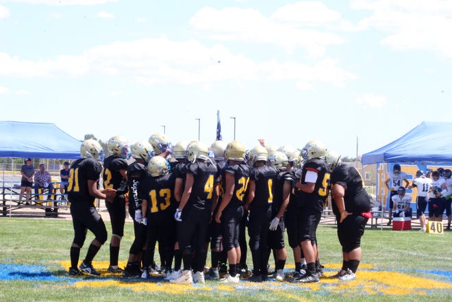 The 2022-23 Dolores Huerta Prep High School Scorpions football team huddle up in the middle of the field pregame before their home opener against Vail Christian on Aug. 27, 2022.