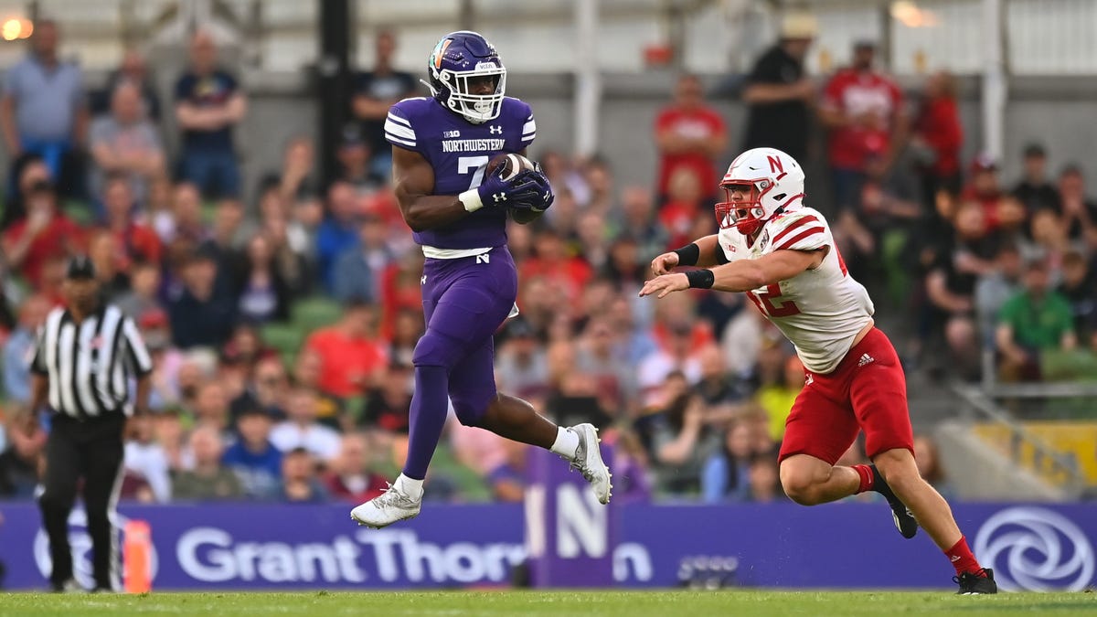 Northwestern running back Anthony Tyus III makes a catch under pressure from Nebraska linebacker Nick Henrich.