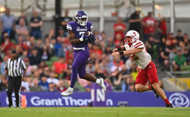 Northwestern running back Anthony Tyus III makes a catch under pressure from Nebraska linebacker Nick Henrich.