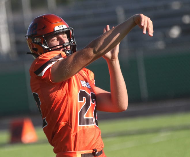 Lucas quarterback Andrew Smollen holds his follow through during warmups before the Cubs played Hillsdale at Clear Fork High School.