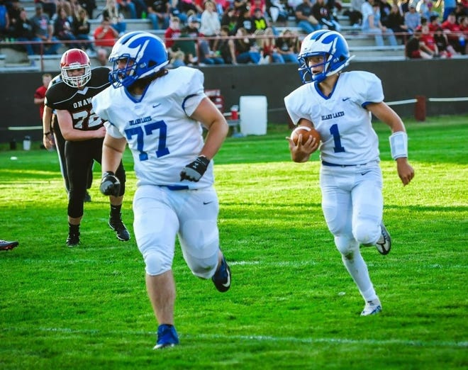 Inland Lakes sophomore quarterback Aidan Fenstermaker (1) rushes the ball while sophomore Jack Wilson (77) blocks during a matchup at Onaway on Friday night.