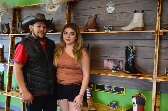 Owners Gerardo and Kaylee Sanchez, stand inside their western apparel shop in Green Bay.