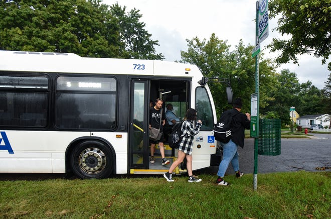 Everett High School students are dropped off near the entrance of the school Monday morning, Aug. 29, 2022, on the first day of school. The Lansing School District dropped traditional bussing for high school students, instead offering CATA bus passes or gas cards.