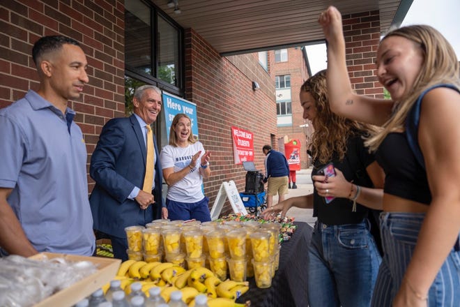 Marquette University President Michael Lovell is joined by basketball coaches Shaka Smart and Megan Duffy in handing out breakfast to students on the first day of classes.