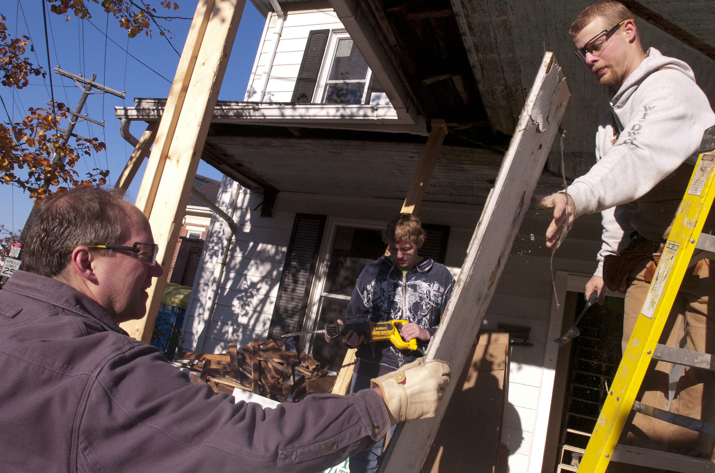 Red Lion high school drafting teacher John Royer, right, hands a piece of wood over to Superintendent Scott Deisley, as the duo joined students in working on a Habitat for Humanity home in 2011.