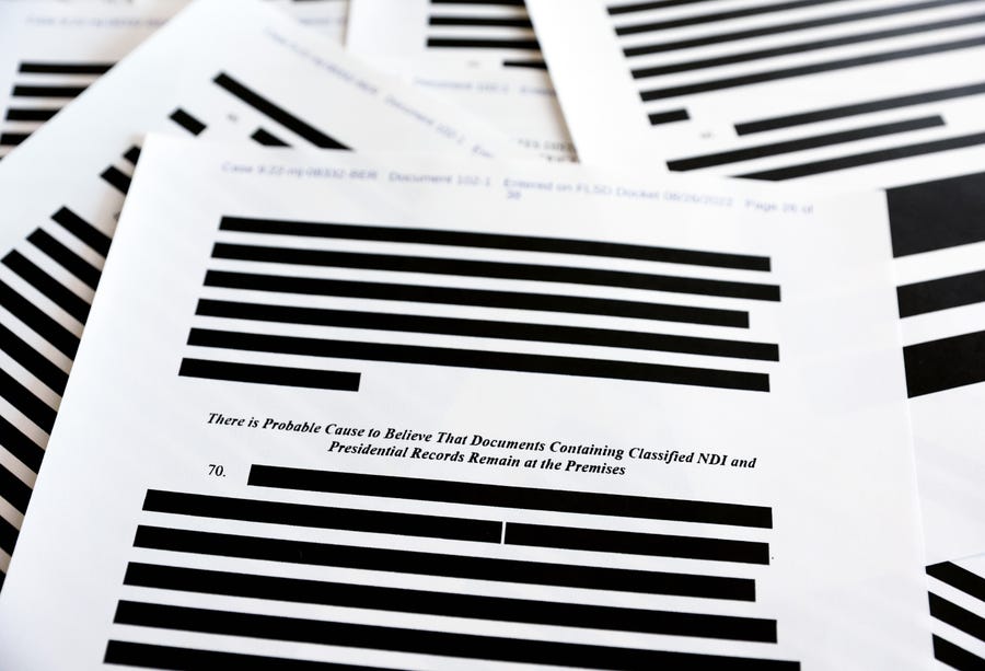 Pages from the government's released version of the F.B.I. search warrant affidavit for former President Donald Trump's Mar-a-Lago estate on August 27, 2022 in California. The 32-page affidavit was heavily redacted for the protection of witnesses and law enforcement and to ensure the 'integrity of the ongoing investigation.