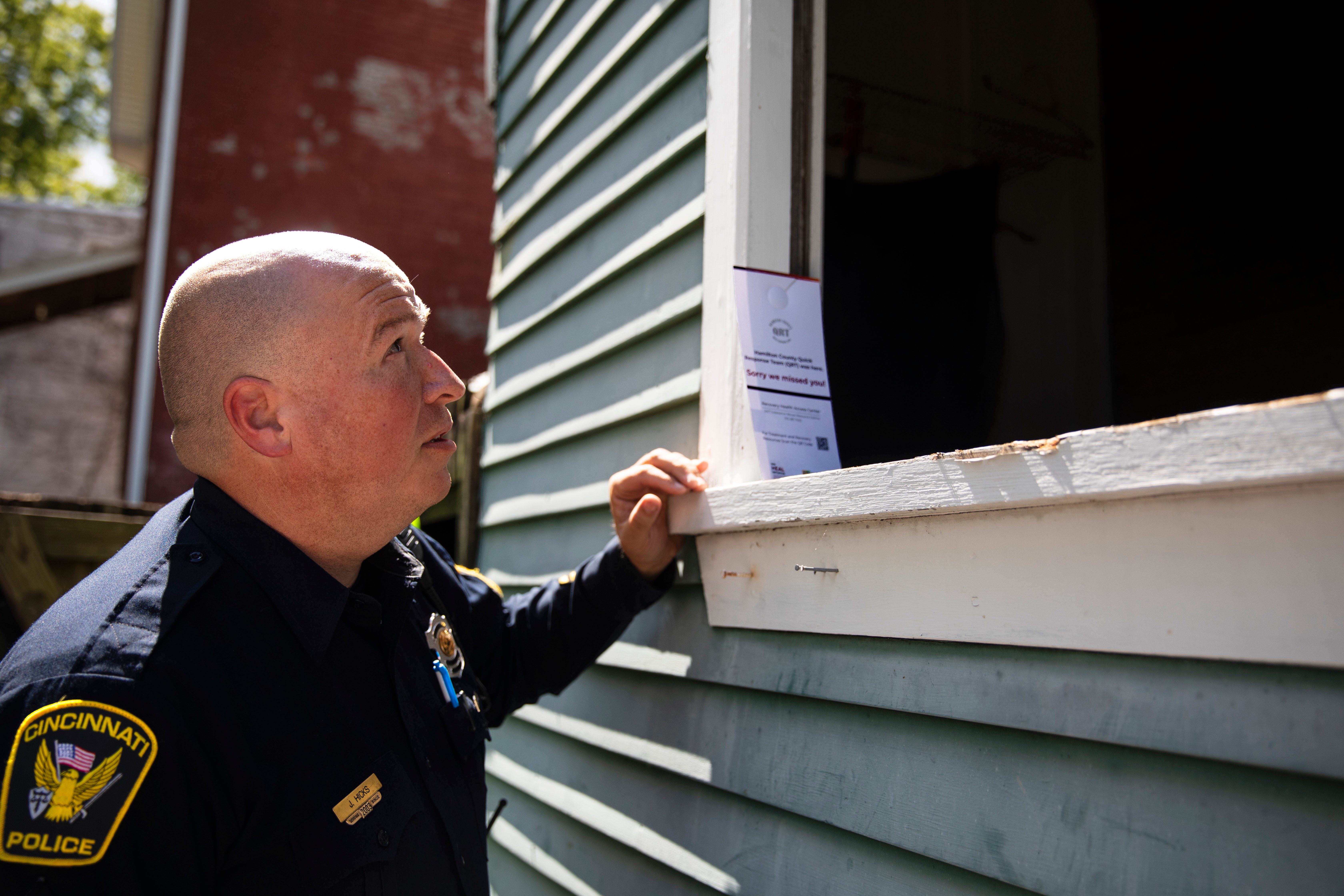 Police Sgt. Jacob Hicks, who leads the Cincinnati Police District 3 Neighborhood Liaison Unit, looks into a broken window at a vacant house that's received complaints about drug use. Hicks' team will find the landlord and work to clean up the property to ensure it does not remain a place for drug use. Instead of simply chasing away or arresting any drug users at these sites, police partner with outreach workers to offer help to prevent overdose and assist them through recovery.