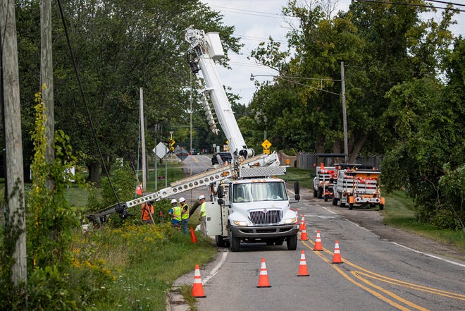 Workers from Underground Contractors repair a downed power line on Ladd Road near West Maple Road in Walled Lake on August 30, 2022.
