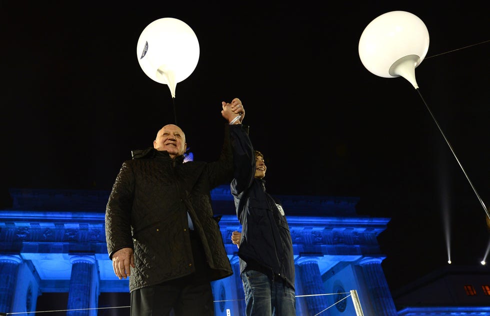 Mikhaïl Gorbatchev attend avant de lâcher un ballon lors d'une fête de rue organisée par le gouvernement allemand pour marquer le 25e anniversaire de la chute du mur de Berlin, devant la porte de Brandebourg le 9 novembre 2014 à Berlin.  Des milliers de ballons illuminés ont navigué dans le ciel nocturne dimanche depuis l'ancien tracé du mur de Berlin.