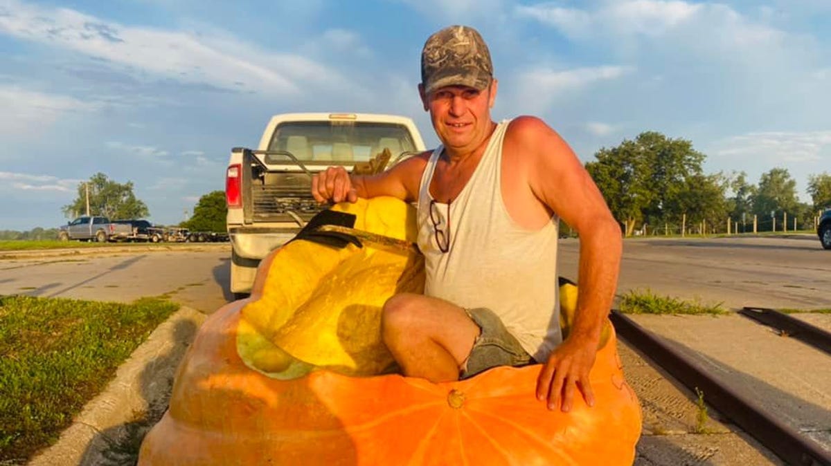 Duane Hansen poses in his enormous pumpkin that he set a world record in.