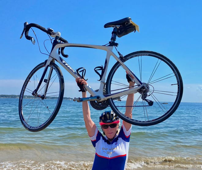 Peorian Kathy Jones celebrates at the end of a 4,000-mile bike trek across America, from Washington state to Gloucester, Mass. in late August.