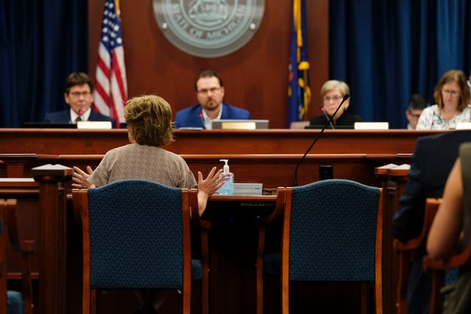 A member of the public speaks in front of the Michigan Board of Canvassers in Lansing on Aug.  31, 2022, regarding ballot initiatives involving voting and reproductive rights.