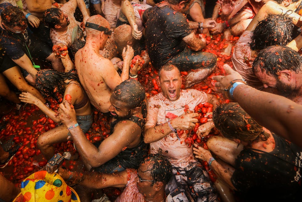Revellers throw tomatoes at each other during the annual "Tomatina", tomato fight fiesta in the village of Bunol near Valencia, Spain, Wednesday, Aug. 31, 2022. The tomato fight took place once again following a two-year suspension owing to the coronavirus pandemic.