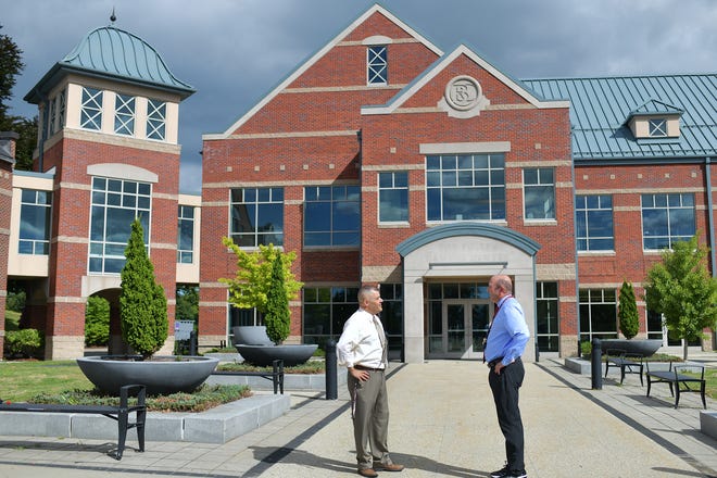 Leicester High School Principal Ted Zawada, left, talks with Brett Kustigian, superintendent of schools, outside the new high school for the town's 11th and 12th graders Thursday. The town bought the former Becker College campus center to use as its new high school.