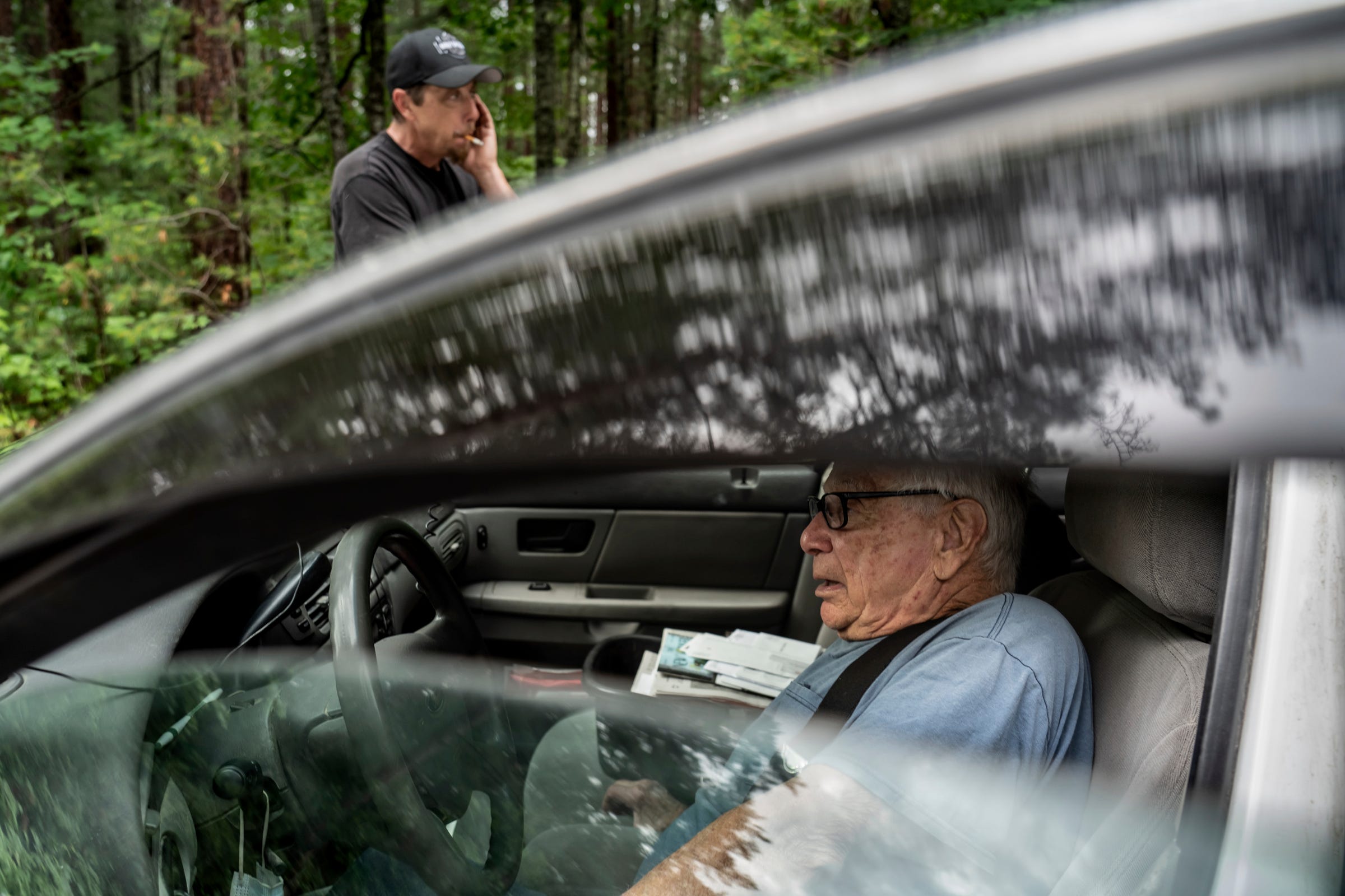 Mailman Ron Curtis, 86, of Wetmore and his trainee Tom Bourdeau, 50, of Wetmore make a pitstop along the side of the road during Curtis's 108-mile long route delivering mail through a section of Michigan's Upper Peninsula on Wednesday, July 27, 2022.