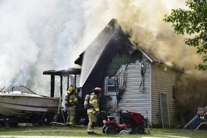 Firefighters work to extinguish a fire in Port Huron Township Thursday.