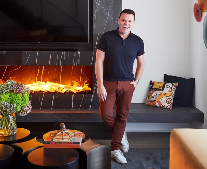 “I adore a book topper,” says interior designer and author John McClain, pictured here with a brass octopus he designed that artfully caps off a stack of books.