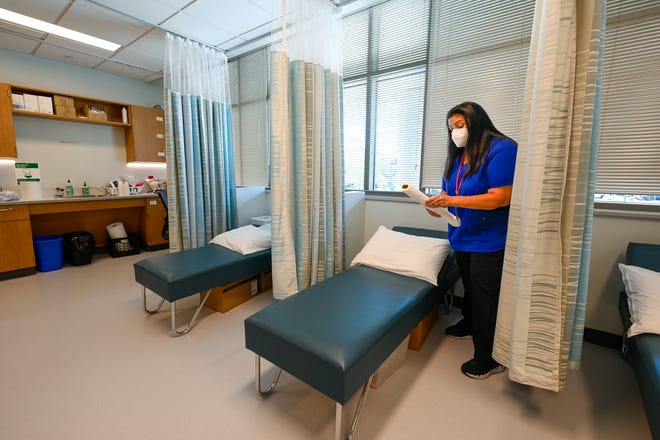 Maria Tully, MSN, RN prepares one of the patient's beds inside Somerville High School's Nursing Office on Thursday, September 1, 2022.