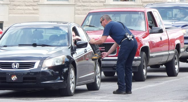 Bucyrus fire Lt. Eric McNutt collects a donation during the firefighters' Fill the Boot campaign benefitting the Muscular Dystrophy Association on Friday at Washington Square.