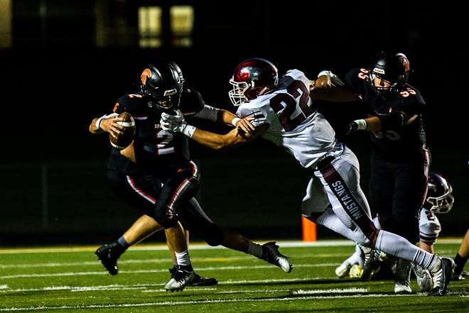 Mount Vernon's Ethan Wood (22) reaches out past the block from Solon center Grant Wilson, right, to tackle quarterback Blake Timmons (2) during a high school football game, Friday, Sept. 2, 2022, at Spartan Stadium in Solon, Iowa.
