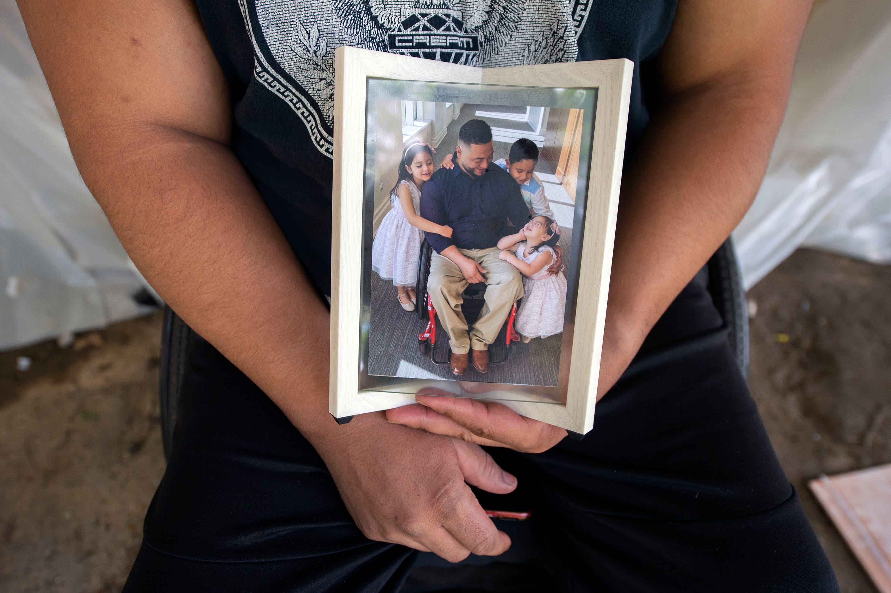 Nelson Fiallos holds a photo of his three children, from left, Milena, 5, Diego, 7, and Juliette, 3, outside his Northeast Jackson home on Friday, Sept. 2, 2022. He and his wife Elena decided to send their children to Honduras to live with their grandmother for a year to keep them safe and away from the water.