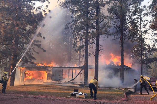 California Department of Forestry and Fire Protection firefighters try to stop flames from the Mill Fire from spreading on a property in the Lake Shastina subdivision northwest of Weed, Calif., Friday, Sept. 2, 2022.