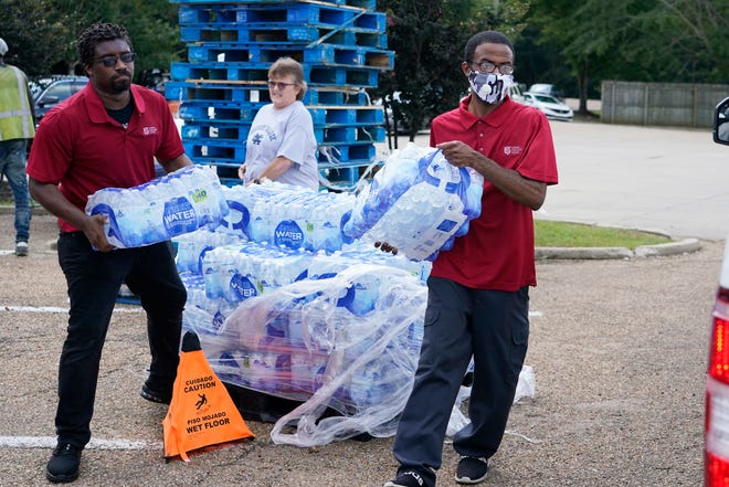 Anggota Salvation Army membawa peti air ke kendaraan yang menunggu di Jackson, Miss., Rabu, 31 Agustus 2022.