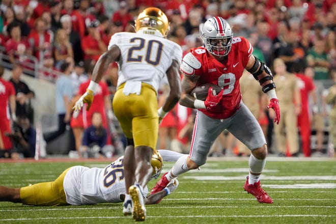 Sep 3, 2022; Columbus, Ohio, USA; Ohio State Buckeyes tight end Cade Stover (8) tries to elude tackle by Notre Dame Fighting Irish wide receiver Chase Dixon (26) and cornerback Benjamin Morrison (20) during the NCAA football game at Ohio Stadium. Mandatory Credit: Adam Cairns-USA TODAY Sports