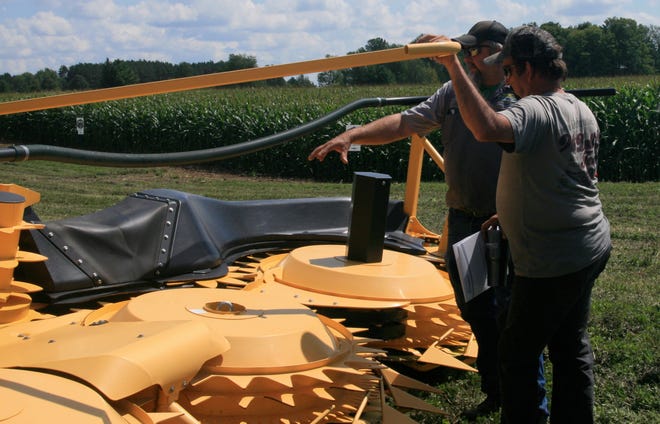 Leon Stahel, left, of the Swiderski service team provided tips for producers when making the switch from the chopper’s hay head to the corn head.