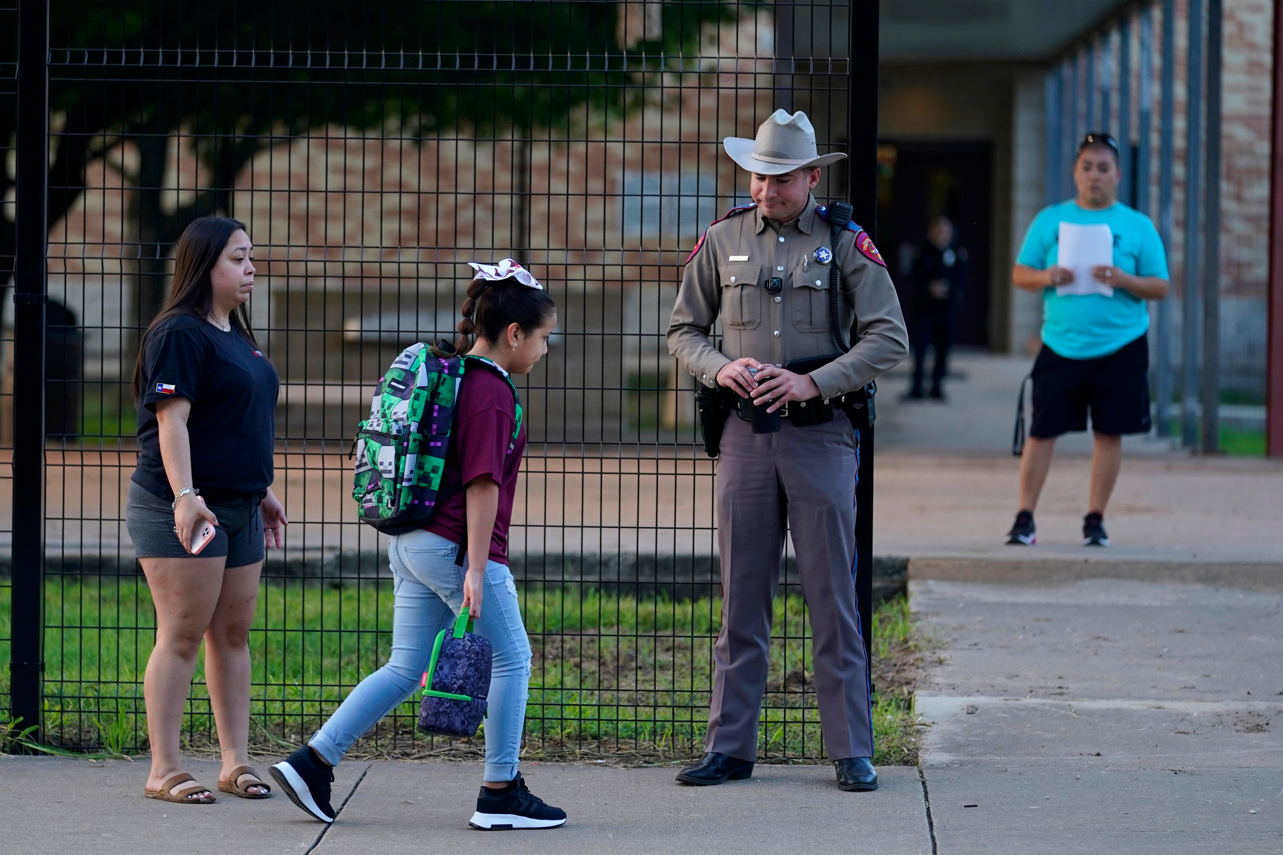 Students arrive at Uvalde Elementary School, now protected by a fence and DPS troopers, for the first day of school Sept. 6 — their first time back at school since the attack at Robb Elementary, which has been closed permanently.