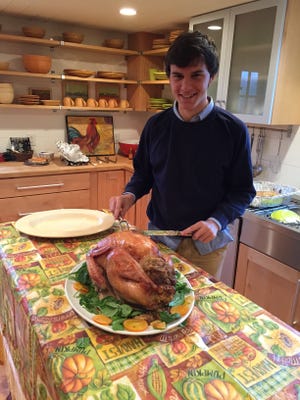 Andrea Massarini, their first exchange student and older brother of current student Marco Massarini, helps carve a Thanksgiving turkey during his stay, during the 2016-2017 school year.