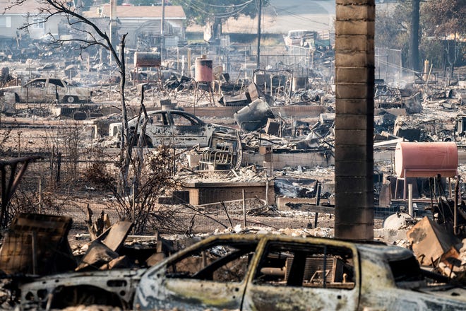 Homes and vehicle destroyed by the Mill Fire line Wakefield Avenue on Saturday, Sept. 3, 2022, in Weed, Calif. (AP Photo/Noah Berger)