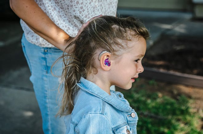 Scarlett Kovacevic wears her hearing aid at her family's home in Lincoln on July 26, 2022. Her family had to pay for the hearing aid out of pocket after her provider experienced billing issues with a state program.