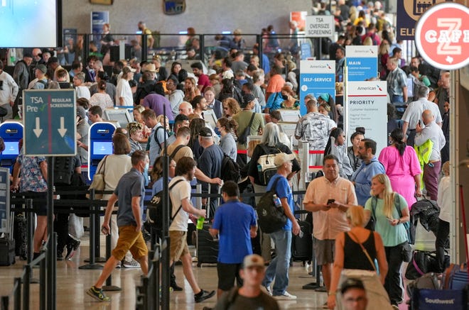 Travelers line up at the ticketing counters after a power outage at Austin-Bergstrom International Airport on Wednesday.